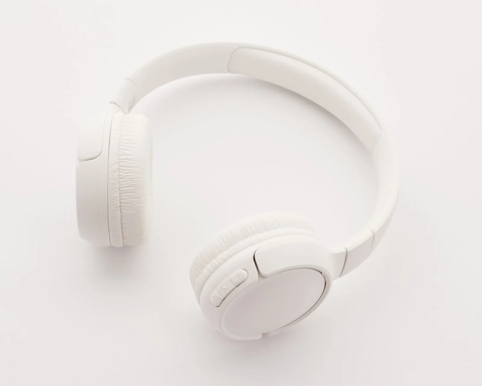 White wireless headphones on a white surface